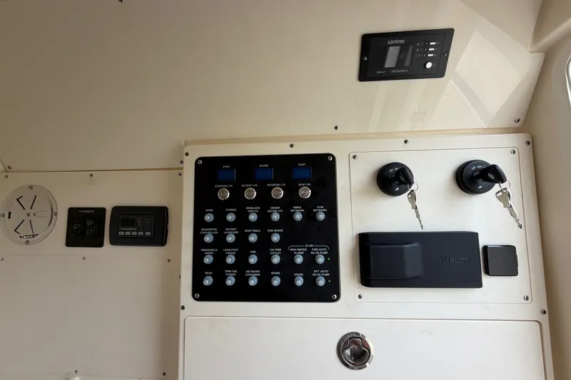 Slide: The Image of Control panel of 2026 Scout 330 LXF boat with switches and keys. - 43