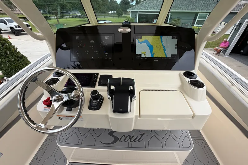 Slide: The Image of 2026 Scout 330 LXF boat dashboard with steering wheel, navigation screens, and controls. - 37