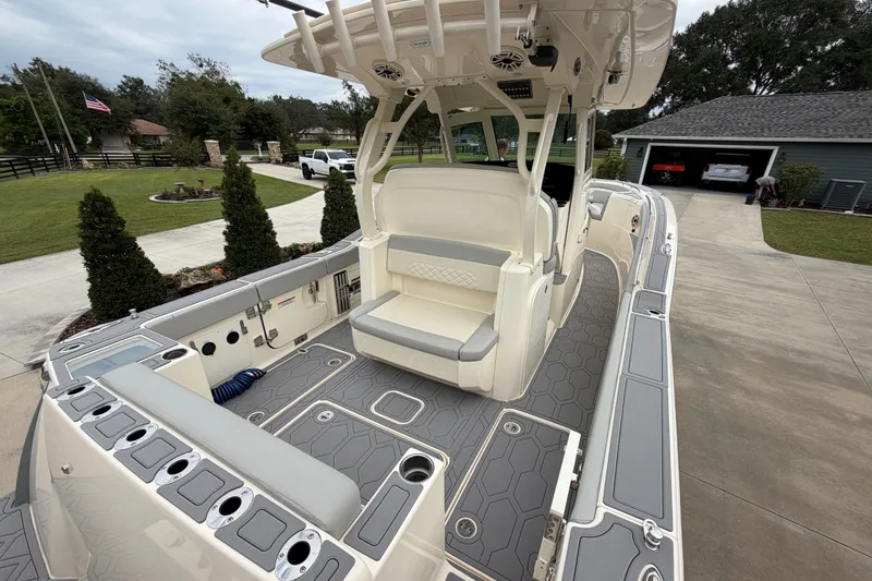 Slide: The Image of 2026 Scout 330 LXF boat with sleek interior design and modern features in a driveway setting. - 25