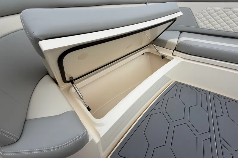Slide: The Image of 2026 Scout 330 LXF boat interior storage compartment with cushioned seating. - 21