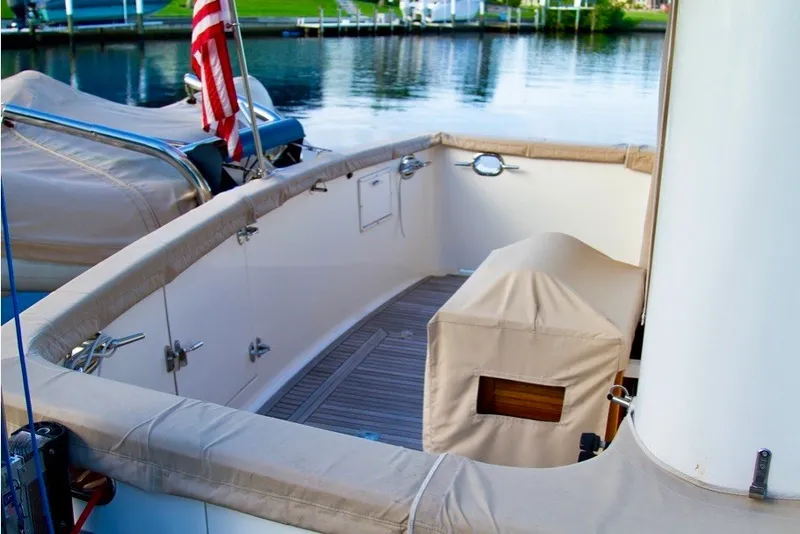 Slide: The Image of Ocean Alexander 430 Classicco 2000 yacht deck with American flag, docked by calm waters. - 4