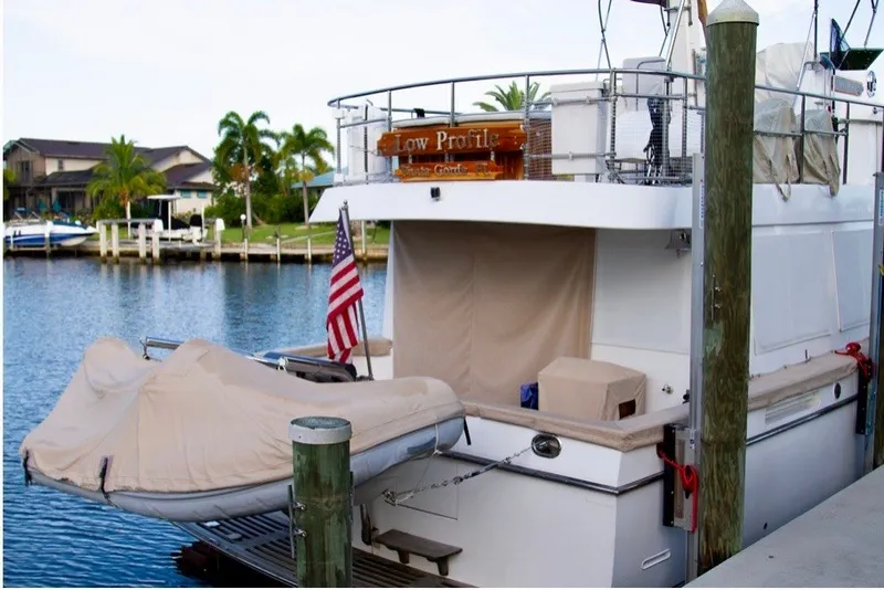 Slide: The Image of Ocean Alexander 430 Classicco yacht docked, featuring covered dinghy and American flag, 2000 model. - 3
