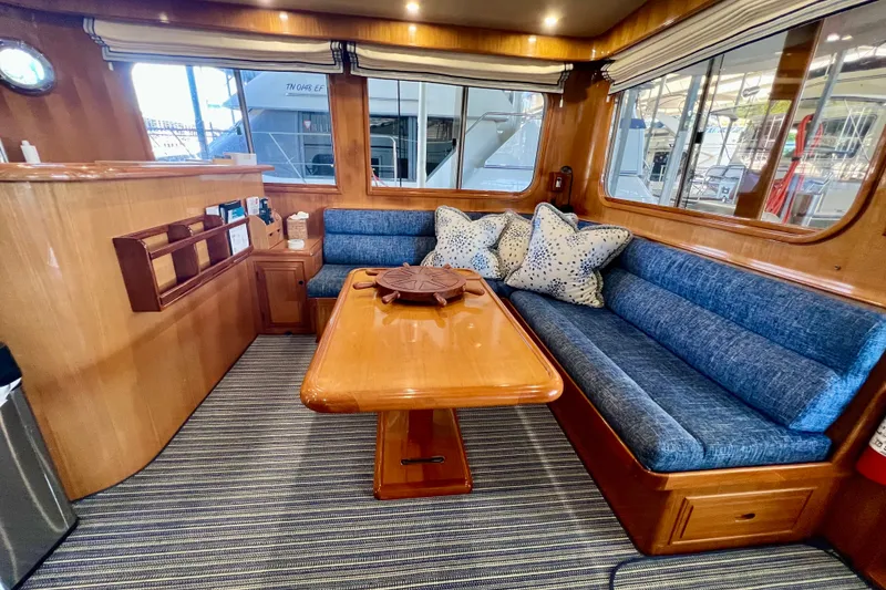 Slide: The Image of Interior of 2000 Ocean Alexander 430 Classicco yacht with blue seating and wooden table. - 11
