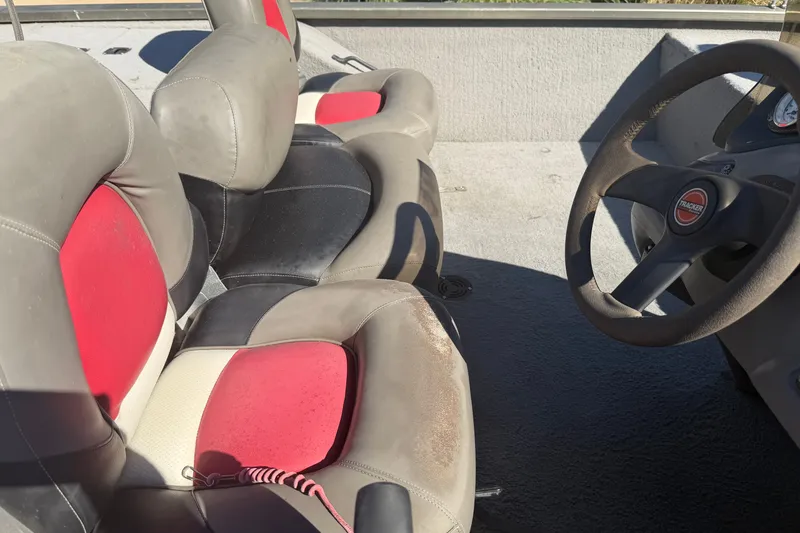 Slide: The Image of 2003 Tracker Tournament V-18 boat interior with red and gray seating and steering wheel. - 16