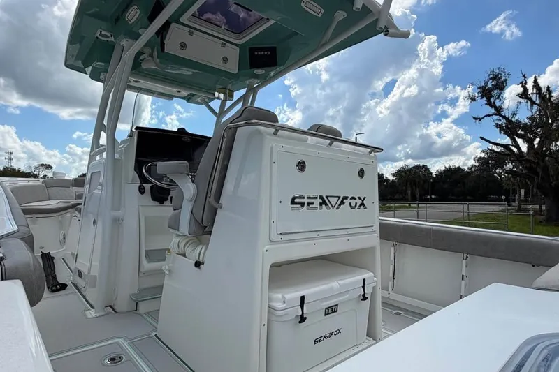 Slide: The Image of 2021 Sea Fox 288 Commander boat interior with helm and seating under blue sky. - 17