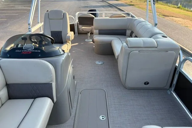 Slide: The Image of 2020 Sun Tracker SportFish 22 XP3 pontoon boat interior with beige seating and helm. - 22