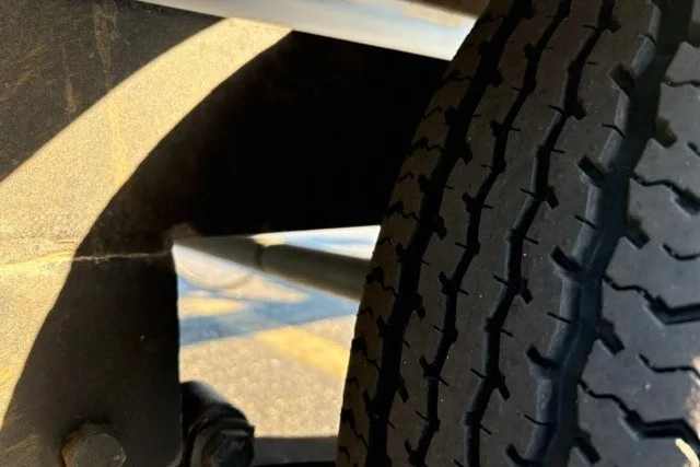 Slide: The Image of Close-up of a 2020 Sun Tracker SportFish 22 XP3 trailer tire and suspension. - 57