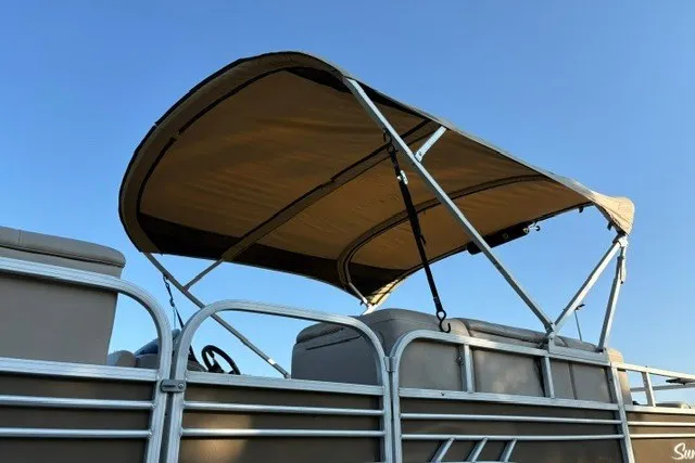 Slide: The Image of 2020 Sun Tracker SportFish 22 XP3 pontoon boat with canopy against blue sky. - 19