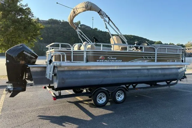 The Image of 2020 Sun Tracker SportFish 22 XP3 pontoon boat on trailer, parked outdoors. - 0