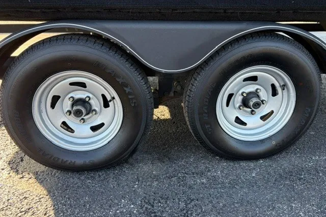 Slide: The Image of Dual trailer wheels of a 2020 Sun Tracker SportFish 22 XP3 on asphalt. - 60