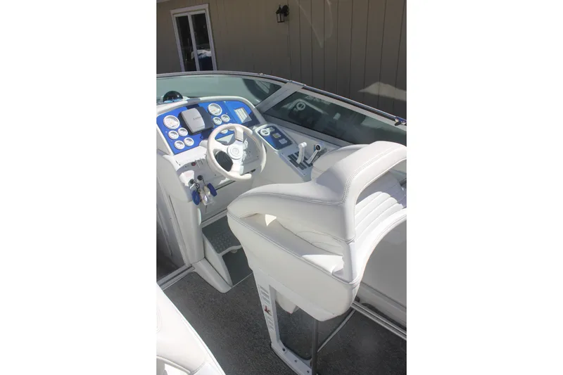 Slide: The Image of 2001 Formula 353 FASTech boat cockpit with white seating and blue dashboard controls. - 12
