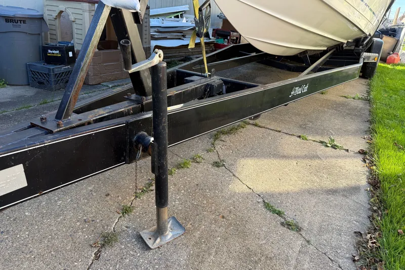 Slide: The Image of Trailer holding a 2001 Formula 353 FASTech boat on a driveway. - 43
