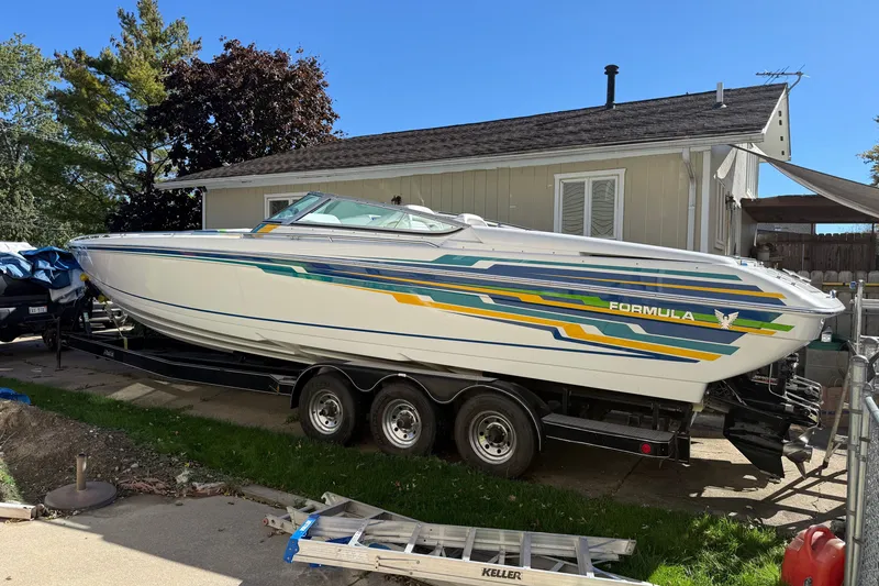 Slide: The Image of 2001 Formula 353 FASTech boat on trailer, parked beside a house. - 2