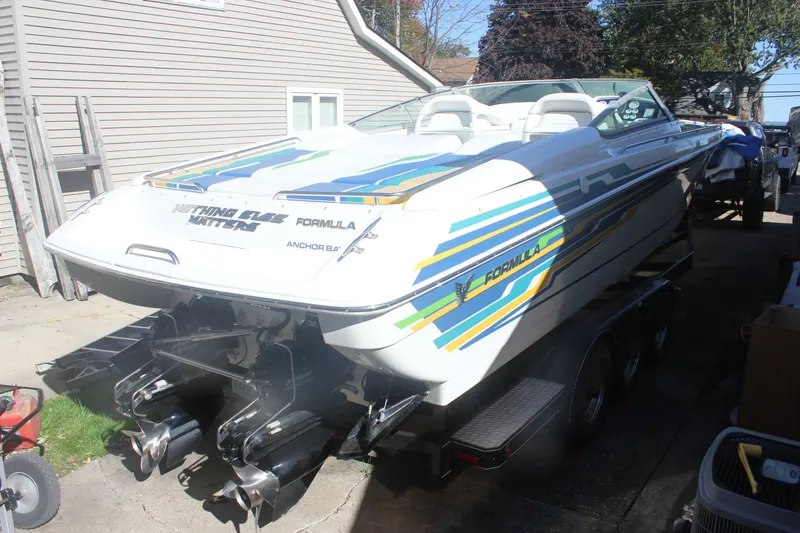 Slide: The Image of 2001 Formula 353 FASTech boat with colorful graphics on a trailer in a driveway. - 6