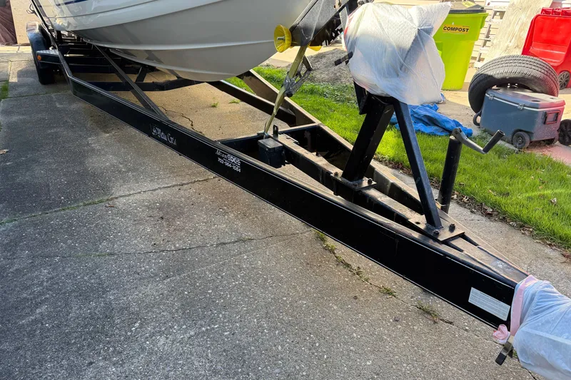 Slide: The Image of Trailer for 2001 Formula 353 FASTech boat on driveway, with covered items nearby. - 42