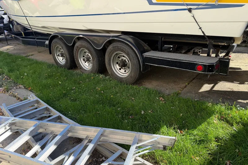 Slide: The Image of Trailer with a 2001 Formula 353 FASTech boat parked on grass beside a metal ladder. - 44