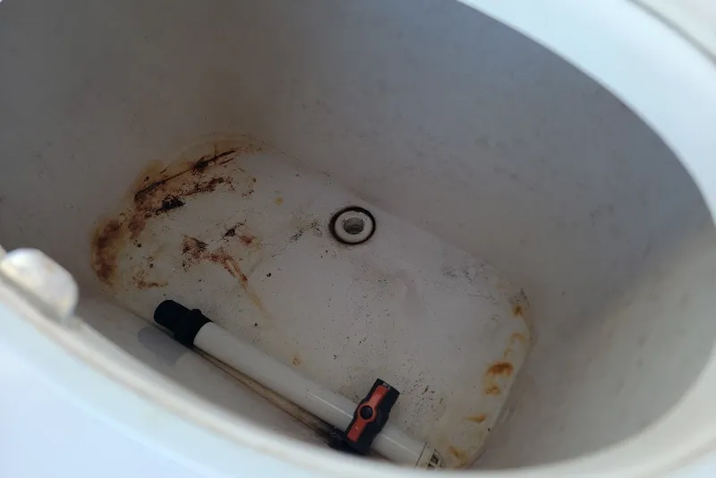 Slide: The Image of 2004 Stamas 310 Tarpon boat compartment with drain and cleaning tool. - 22