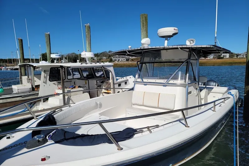 Slide: The Image of 2004 Stamas 310 Tarpon boat docked at marina under clear blue sky. - 1