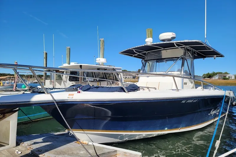 The Image of 2004 Stamas 310 Tarpon boat docked at marina under clear blue sky. - 0