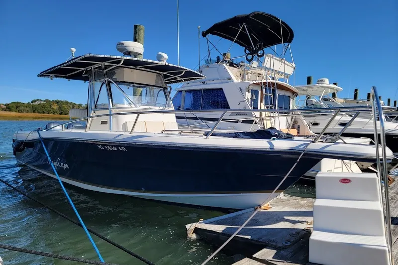 Slide: The Image of 2004 Stamas 310 Tarpon boat docked at marina under clear blue sky. - 23