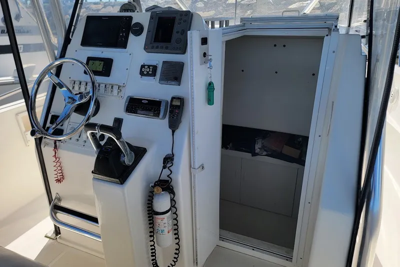 Slide: The Image of 2004 Stamas 310 Tarpon boat cockpit with steering wheel, control panel, and cabin entrance. - 7