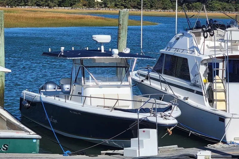 Slide: The Image of 2004 Stamas 310 Tarpon boat docked in a serene marina setting. - 28