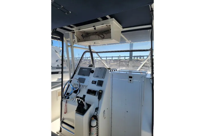 Slide: The Image of 2004 Stamas 310 Tarpon boat helm with steering wheel and navigation controls. - 26