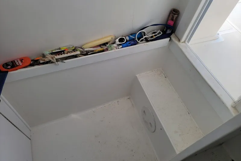 Slide: The Image of Interior of a 2004 Stamas 310 Tarpon boat with storage compartment and various items. - 8