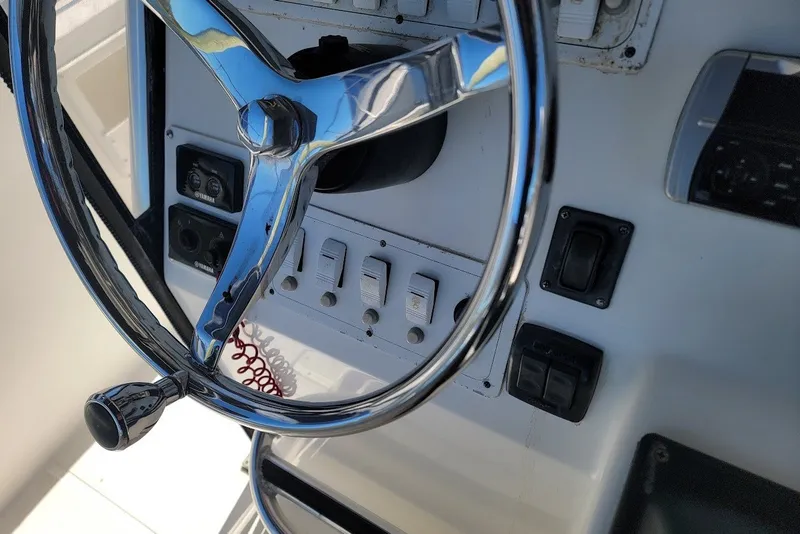 Slide: The Image of Steering wheel and controls of a 2004 Stamas 310 Tarpon boat. - 15