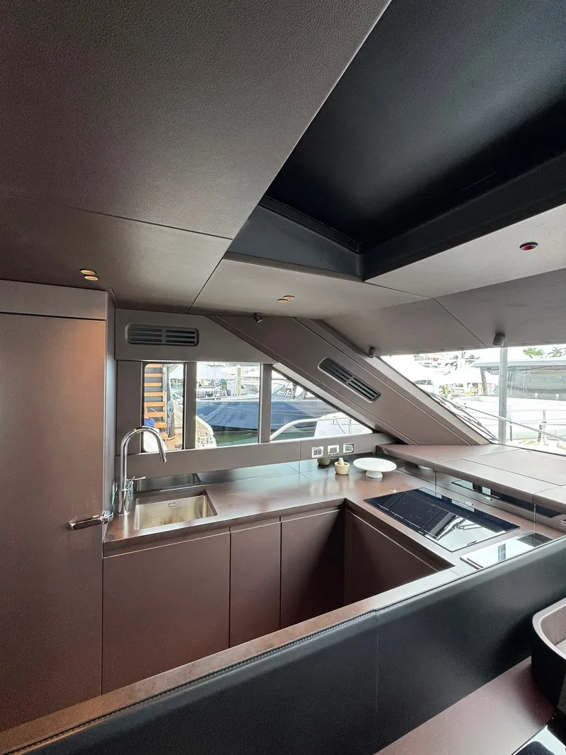 Slide: The Image of Modern kitchen in a Cranchi Sessantassette 67 yacht, featuring sleek surfaces and large windows. - 14