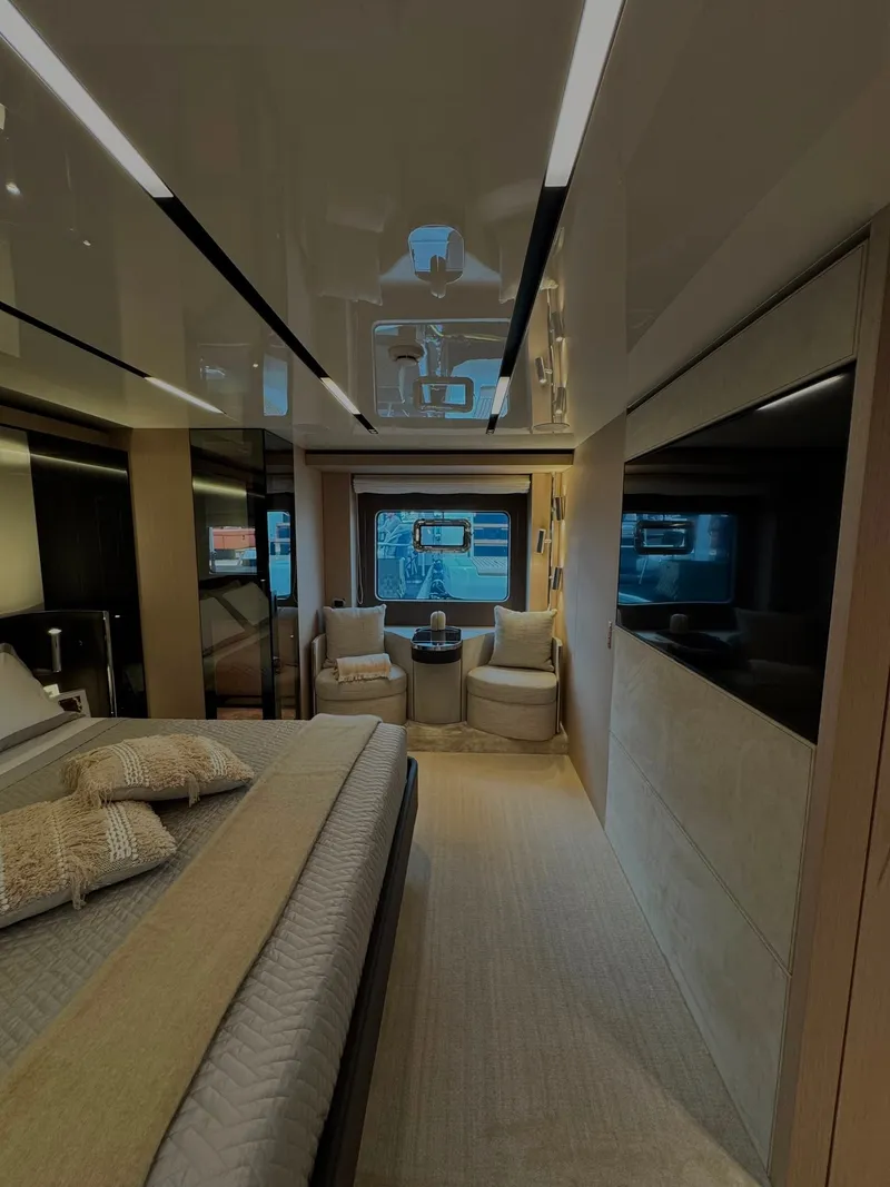 Slide: The Image of Luxurious cabin with a double bed, two armchairs, and large windows on a modern yacht. - 16