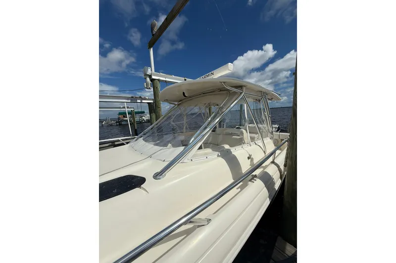 Slide: The Image of 2004 Intrepid 348 Walkaround boat docked under a clear blue sky. - 15