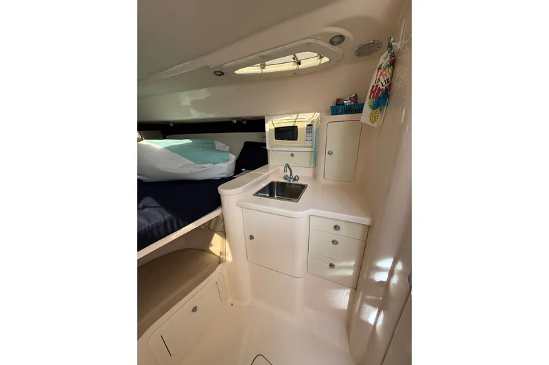Slide: The Image of 2004 Intrepid 348 Walkaround cabin interior with kitchenette and bed. - 41