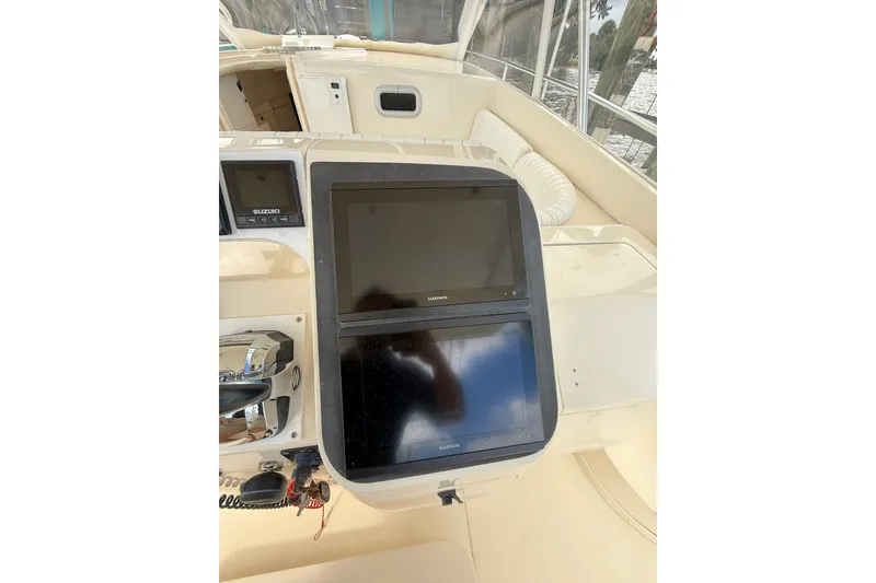 Slide: The Image of 2004 Intrepid 348 Walkaround helm with Garmin displays and Suzuki controls. - 31