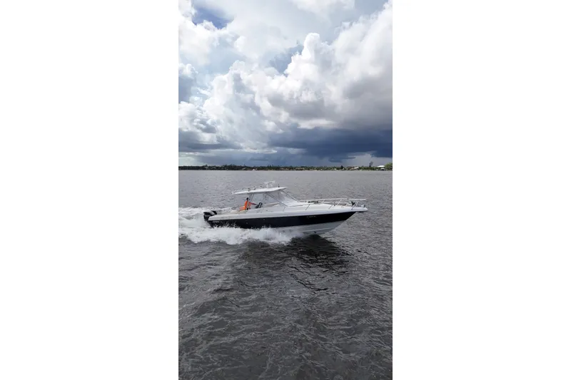 The Image of 2004 Intrepid 348 Walkaround boat cruising on a cloudy day. - 4