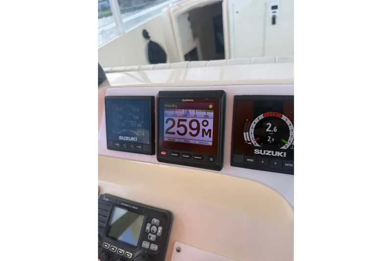 Slide: The Image of Boat dashboard with Suzuki and Garmin displays on a 2004 Intrepid 348 Walkaround. - 33