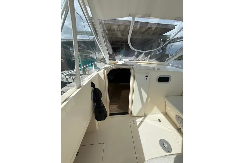 Slide: The Image of 2004 Intrepid 348 Walkaround boat interior with open cabin door and seating area. - 37
