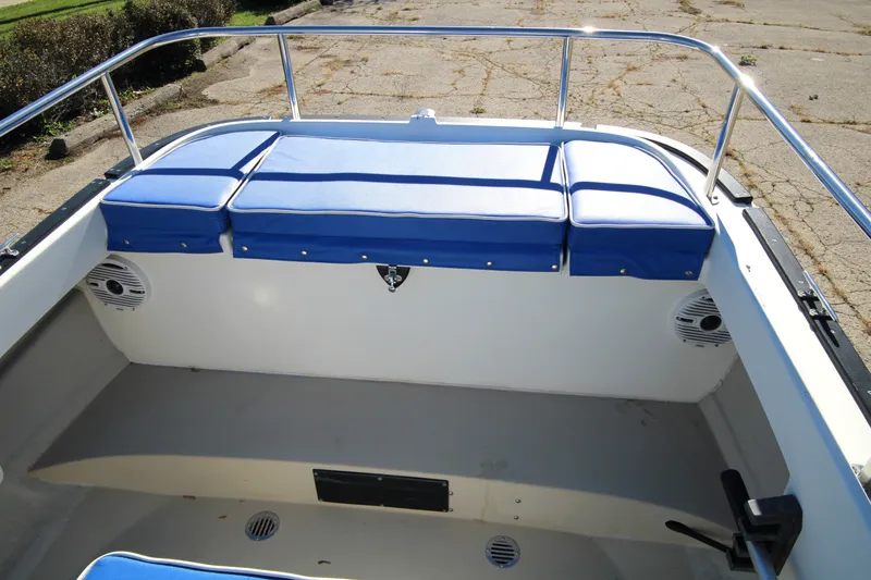 Slide: The Image of 2005 Ranger Tugs R-21 boat interior with blue cushioned seating and stainless steel railings. - 13