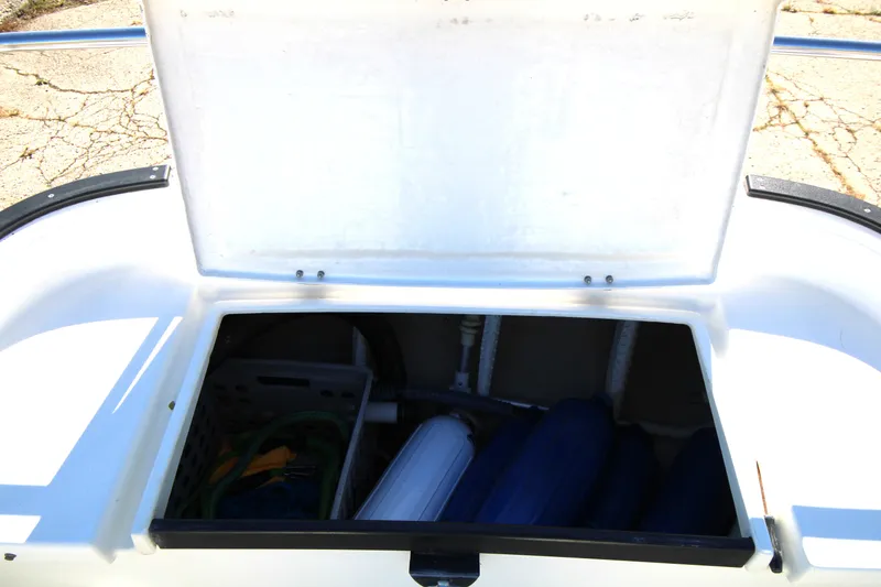 Slide: The Image of Open storage compartment on a 2005 Ranger Tugs R-21 boat, showing interior contents. - 25