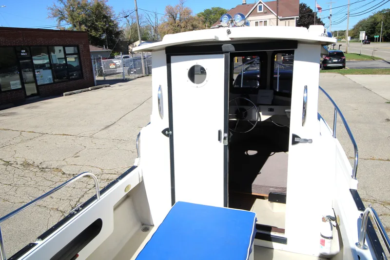 Slide: The Image of 2005 Ranger Tugs R-21 boat with open cabin door, parked outdoors. - 14