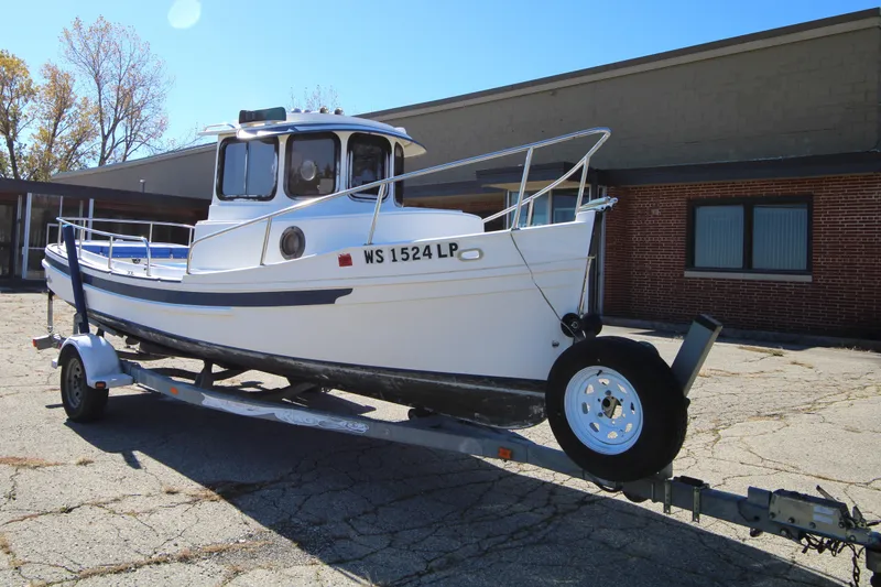 The Image of 2005 Ranger Tugs R-21 boat on trailer, parked outdoors near a building. - 0