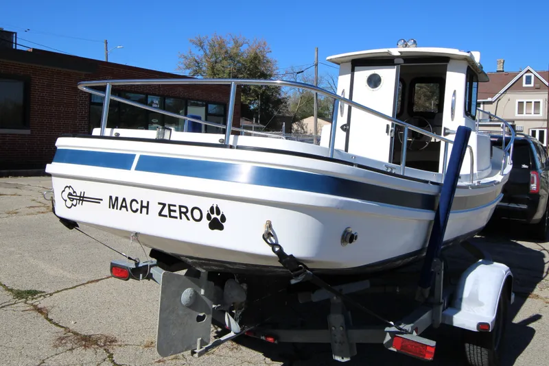 Slide: The Image of 2005 Ranger Tugs R-21 boat named "Mach Zero" on a trailer in a parking lot. - 4