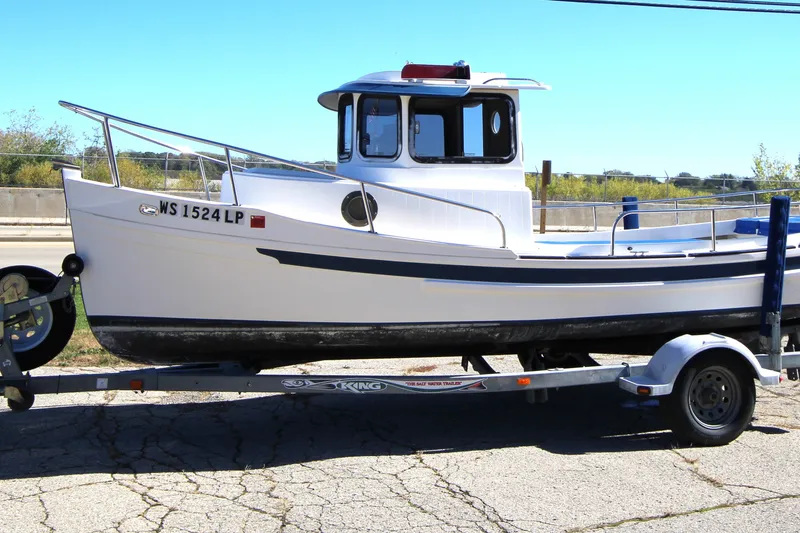 Slide: The Image of 2005 Ranger Tugs R-21 boat on trailer, parked outdoors on a sunny day. - 2