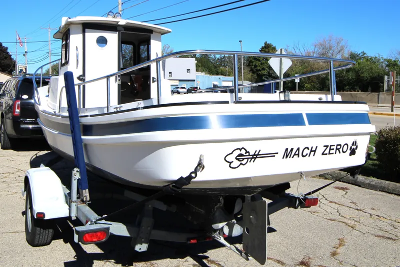 Slide: The Image of 2005 Ranger Tugs R-21 boat named "Mach Zero" on a trailer in a parking lot. - 3