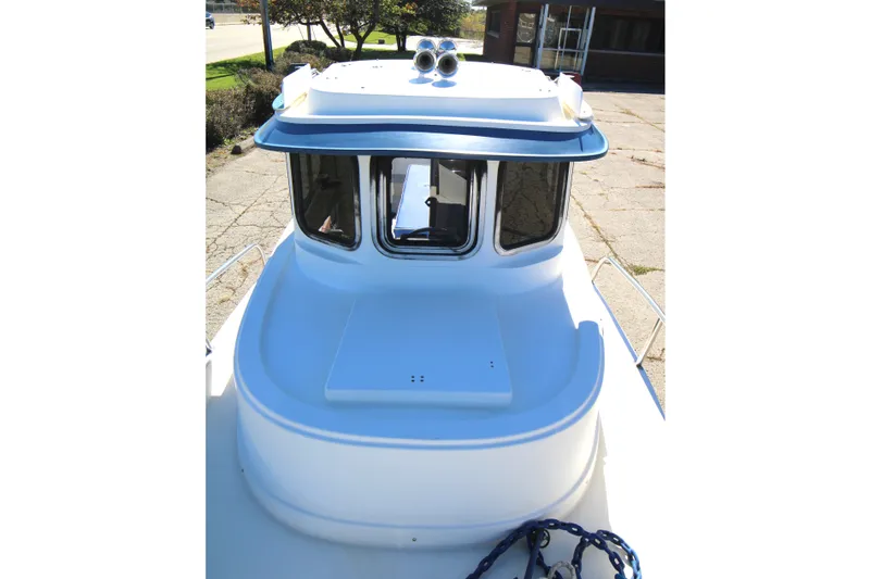 Slide: The Image of 2005 Ranger Tugs R-21 boat, front view with windows and deck details. - 8