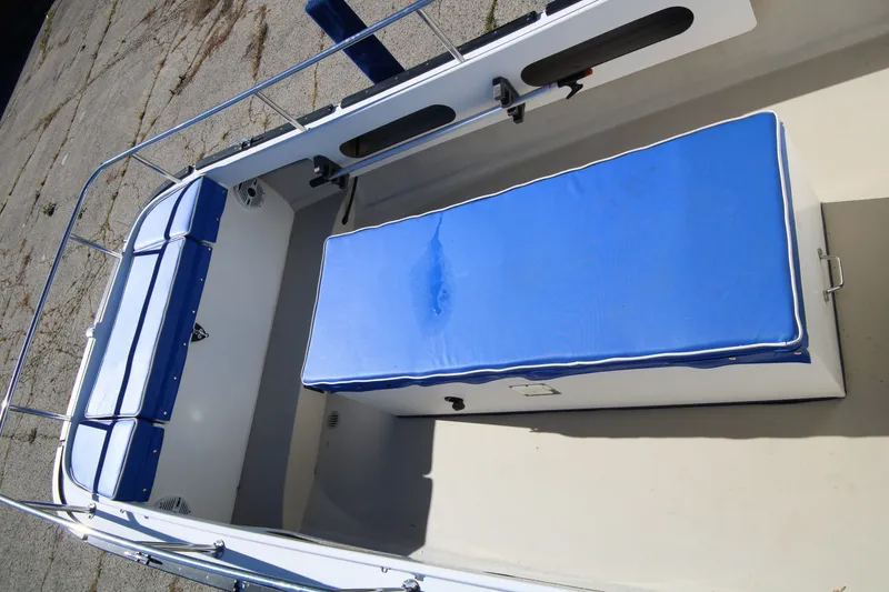 Slide: The Image of 2005 Ranger Tugs R-21 boat interior with blue cushioned seating and white deck. - 6