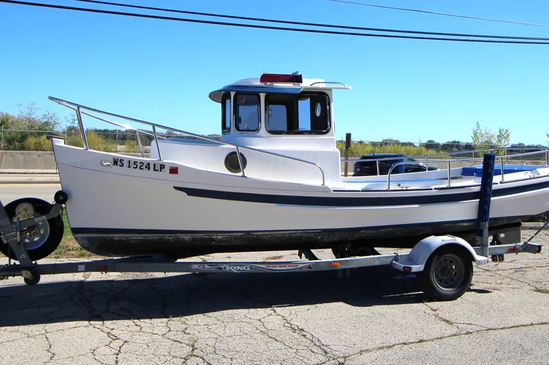 Slide: The Image of 2005 Ranger Tugs R-21 boat on trailer, parked outdoors under clear blue sky. - 1