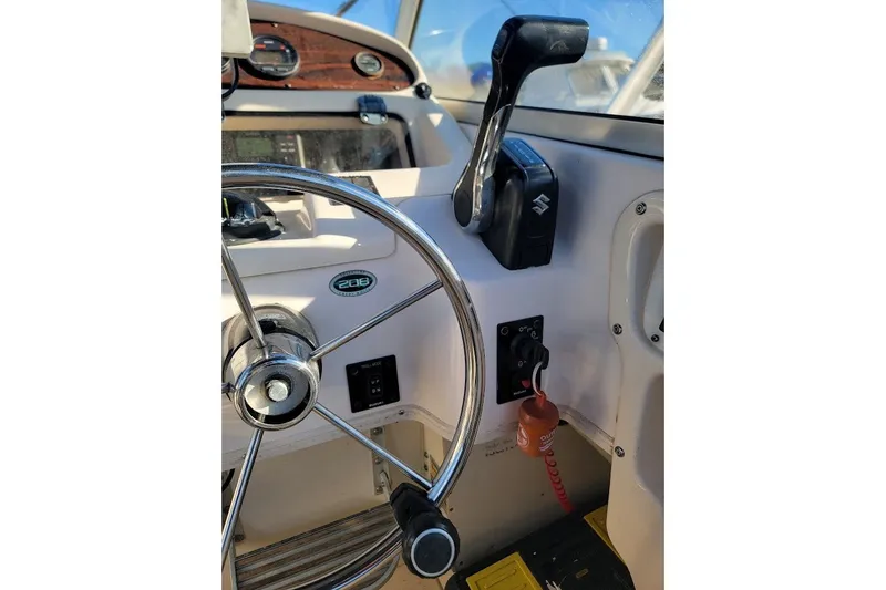 Slide: The Image of Steering wheel and controls of 1999 Grady-White Adventure 208 boat cockpit. - 6