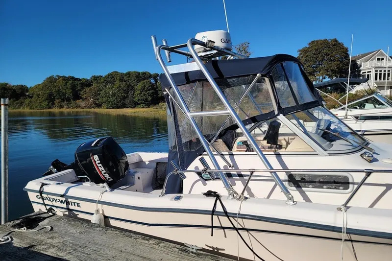 Slide: The Image of 1999 Grady-White Adventure 208 boat docked by serene waters, clear blue sky. - 11