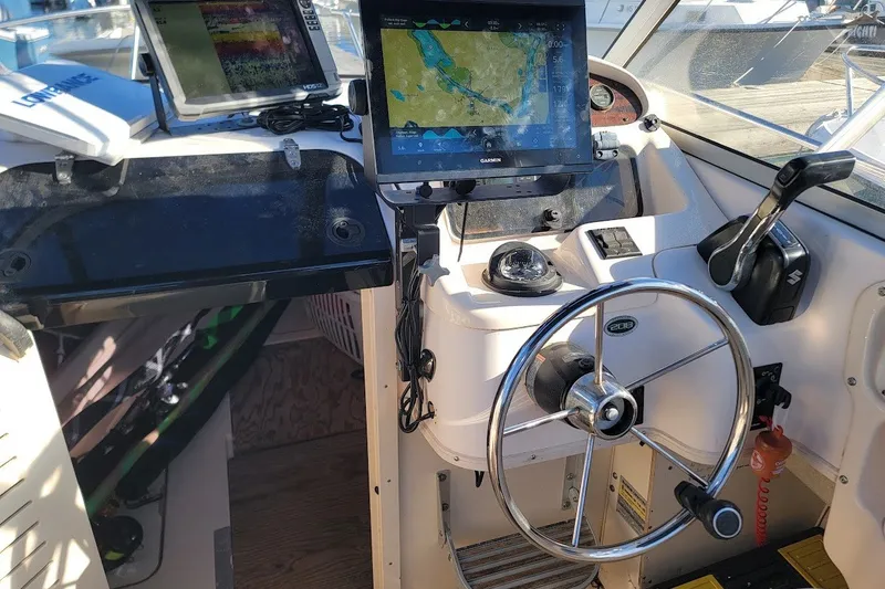 Slide: The Image of 1999 Grady-White Adventure 208 boat cockpit with navigation equipment and steering wheel. - 5